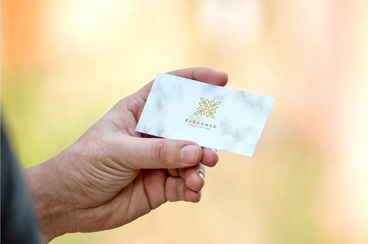 A branded business card held up to the camera